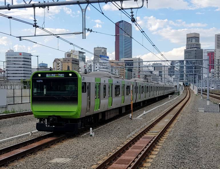 A Yamanote Line E235 series EMU approaching Takanawa Gateway Station